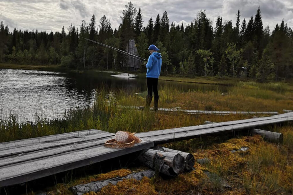 Poika kalastamassa lammen reunalla