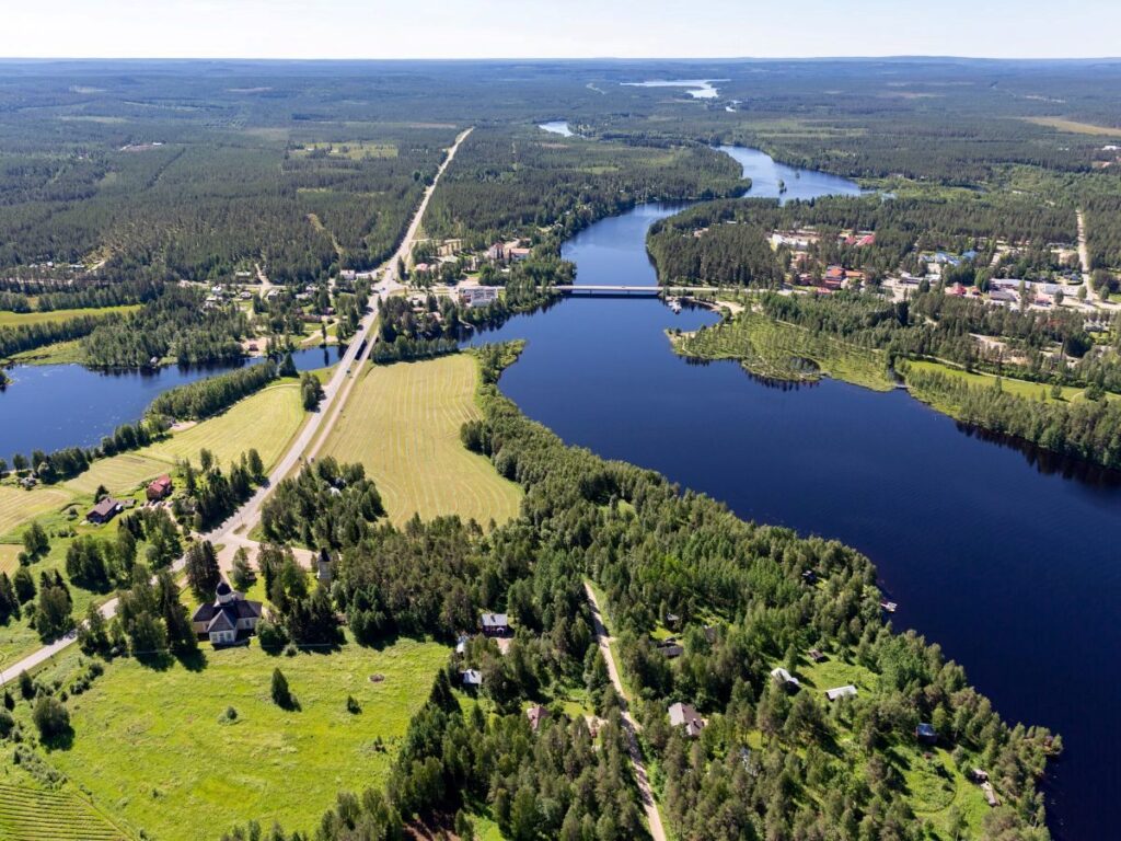 Ilmakuva Hyrynsalmen keskustasta. Kuvassa näkyy puita, vettä ja rakennuksia.